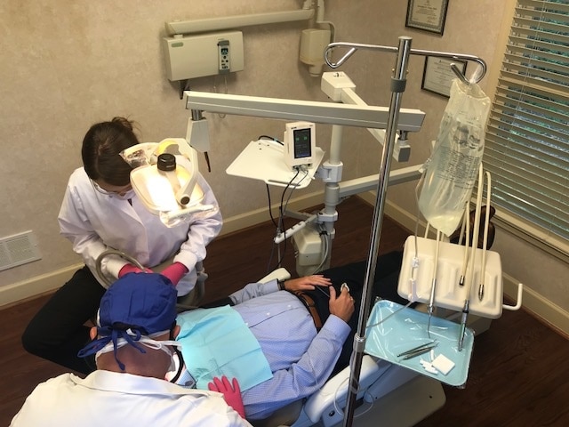 Dentist and his assistant actively working on a patient