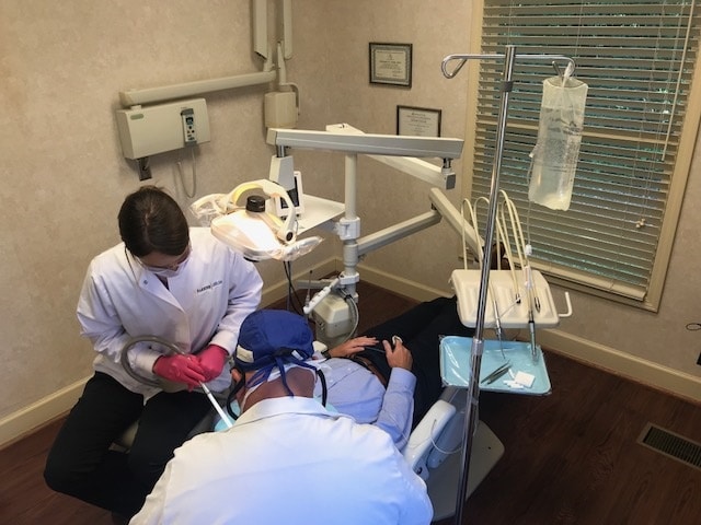 Dentist and his assistant actively working on a patient